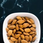 a white bowl filled with almonds on top of a table